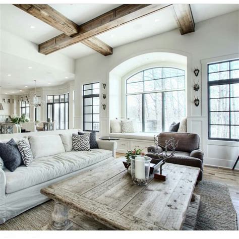 A Living Room Filled With White Furniture And Lots Of Wood Beams On The