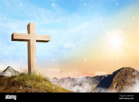 Christian Cross On The Of Mountain With Clouds Fog Over Sunrise