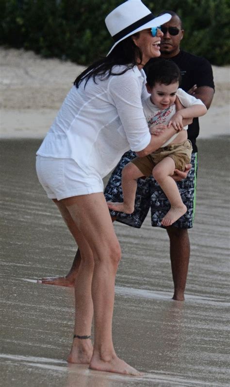 lauren silverman flaunts her assets in an unbuttoned shirt as she plays on the beach with son