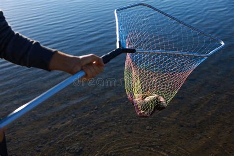 Fisherman Holding Fishing Net With Catch At Riverside Closeup Stock