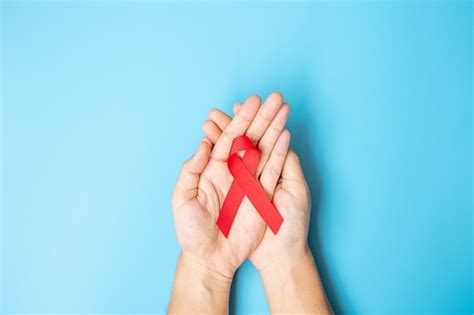 Premium Photo Man Holding Red Ribbon For Supporting People Living And Illness Healthcare And
