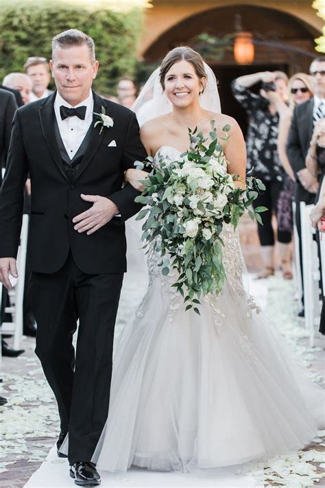 Father Of The Bride Walking Down The Aisle With One Arm Around The Bride While Wearing A Black