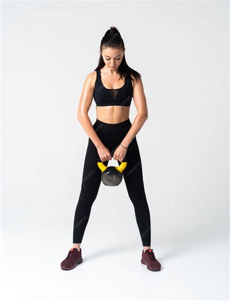 premium photo fitness woman exercising crossfit holding kettle bell