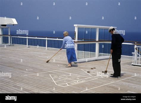 A Couple Playing Deck Shuffleboard On A Cruise Ship Stock Photo