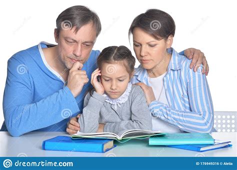 Portrait Of Sad Parents With Daughter Doing Homework Stock Photo