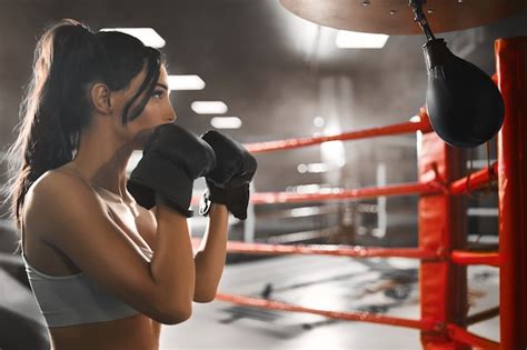 premium photo side view of fit sexy concentrated brunette woman wearing boxing gloves