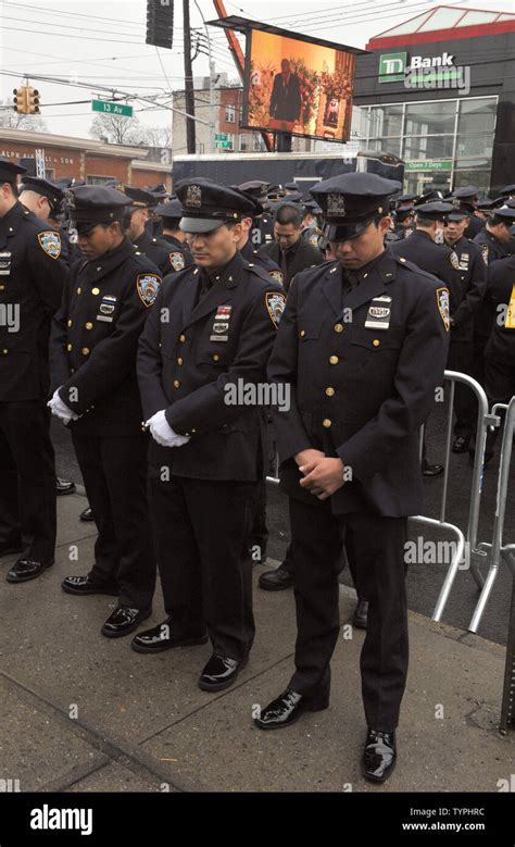 Nypd Police Officers Stand Outside And Bow Their Heads At The Funeral