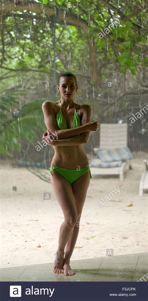 Young Woman Wearing Bikini Standing In Tropical Rain Storm