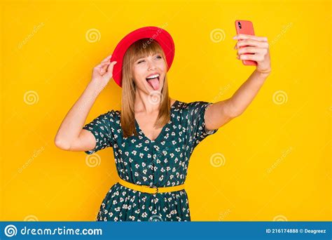 portrait of lovely crazy cheerful girl taking selfie posing touching hat showing tongue tease