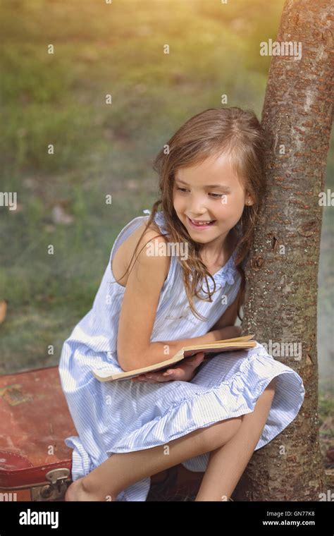 Joyful Young Girl Reading A Book Stock Photo Alamy