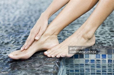 Woman Rubbing Her Foot At The Poolside High Res Stock Photo Getty Images