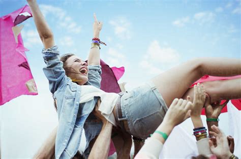 Enthusiastic Woman Crowd Surfing At Music Festival Stock Photo