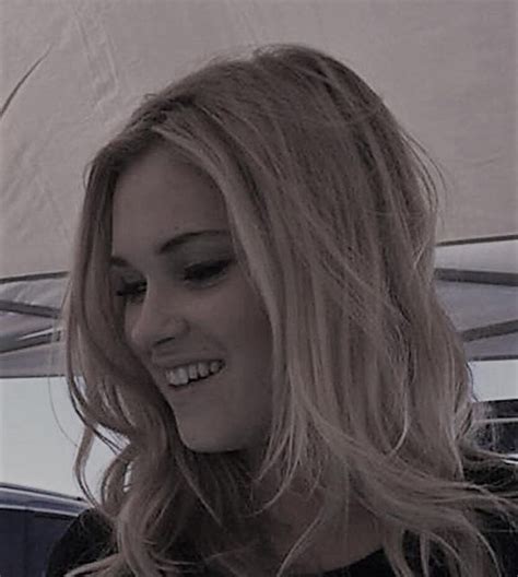 A Woman With Long Blonde Hair Is Smiling