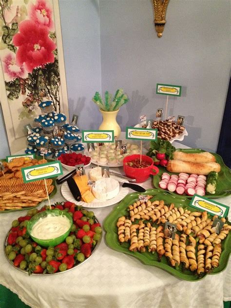 A Table Topped With Lots Of Different Types Of Foods And Desserts Covered In Green Plates