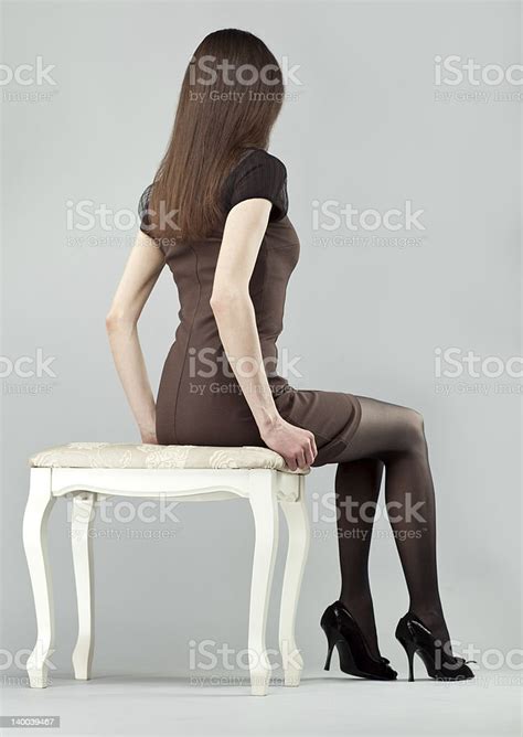 Elegant Longhaired Brunette Girl In Dress Sitting On A Chair Stock
