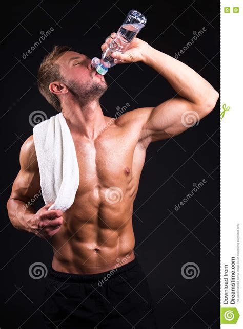 Young Muscular Man After Training Drinking Water From The Bottle Stock