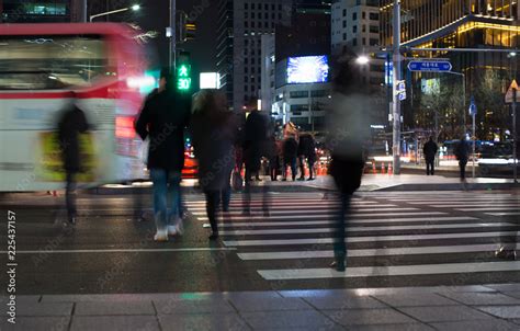 Street Scene With People Crossing The Street At Night Crowd Of Busy People Walking In Major