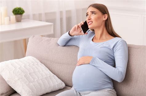 Pregnant Lady Calling Doctor Feeling Bad Sitting On Sofa Indoor Stock Image Image Of Emergency