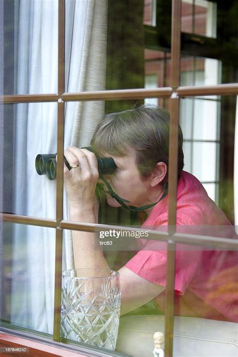 Nosey Neighbour At The Window With Binoculars High Res Stock Photo