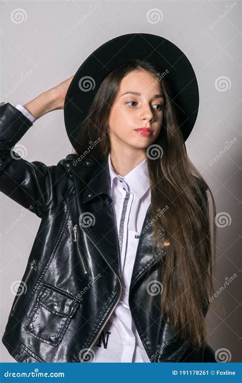 Una Adolescente Con Una Chaqueta De Cuero De Moda Y Un Sombrero De Par En Par Con Fondo Blanco