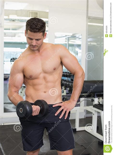 Shirtless Focused Bodybuilder Lifting Heavy Black Dumbbell Stock