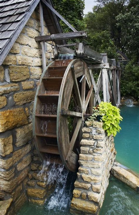 An Old Mill With Water Coming Out Of It
