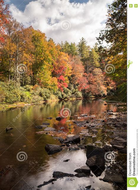 River Reflection With Fall Foliage And Trees In The Background Stock