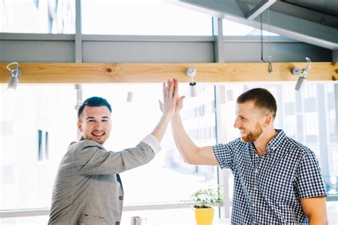 Free Photo Cheerful Men High Fiving In Office