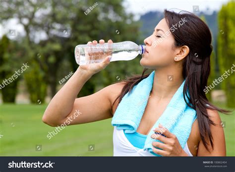 Athletic Woman Drinking Water After Exercising Outdoors Stock Photo