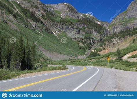 Mountain Road Curves In Front Of Large Mountains In Colorado Stock