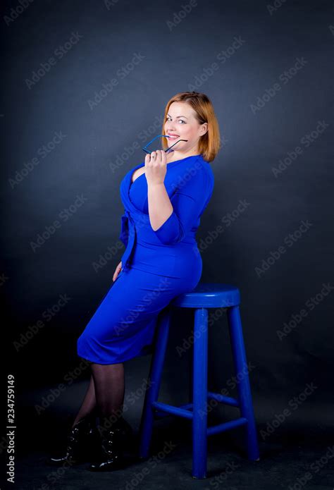beautiful chubby girl in blue elegant dress on a black background sexy plus size woman stock