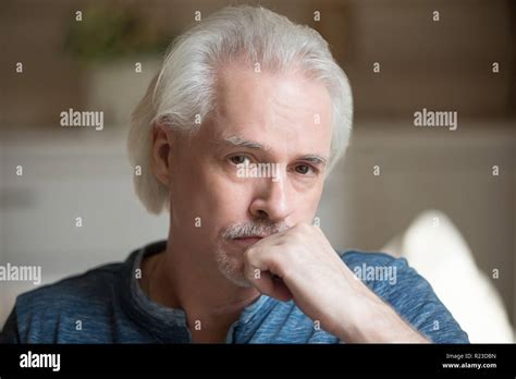 Portrait Of Sad Aged Man Looking At Camera Thinking About Life