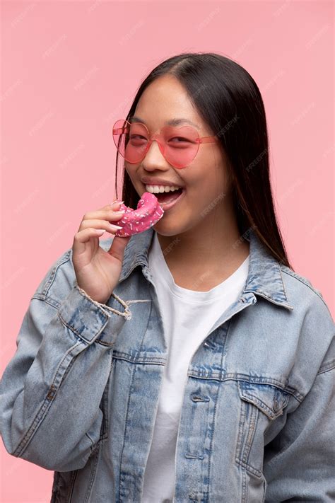 Retrato De Uma Jovem Adolescente Comendo Uma Rosquinha Foto Grátis