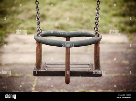 Empty Swing In Playground On The Grass Stock Photo Alamy