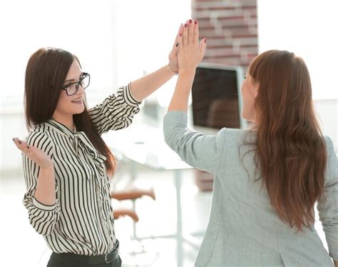 Premium Photo Two Young Coworkers Giving Each Other A High Five
