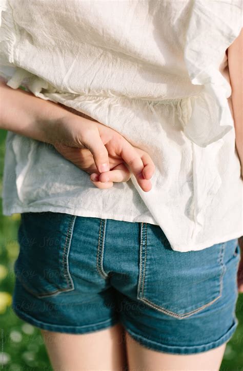 Tween Girl With Her Fingers Crossed Behind Her Back By Helen Rushbrook