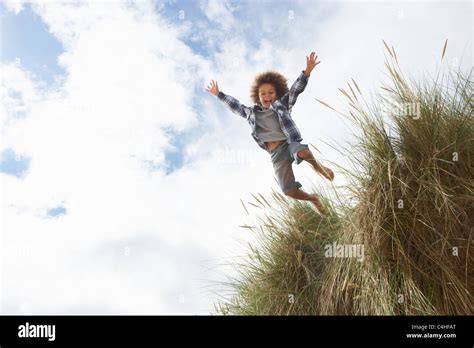 Boy Jumping Over Dune Stock Photo Alamy