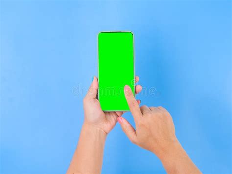 Female Hand Holding Smartphone With Mockup Green Screen On Blue