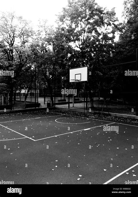 Black And White Photography Of An Empty Court With Basketball Hoop