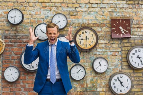 Man In Suit Standing Near Wall With Clocks Stock Photo Image Of