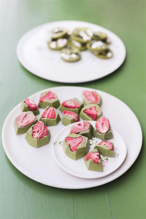 Leckere nachtische mit erdbeere auf weißen keramischen platten über grüner tabelle | Kostenlose Foto
