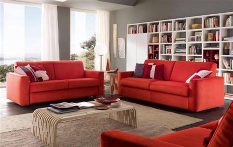 A Living Room Filled With Red Furniture And Bookshelves
