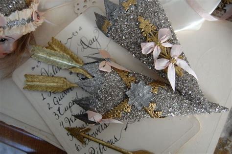 Two Silver And Gold Hair Clips On Top Of A White Envelope Next To A Doll