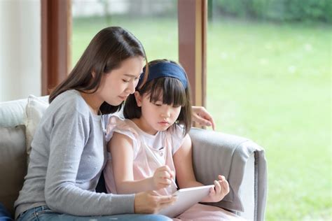 Feliz Madre Asiática Enseñando A Su Linda Hija A Estudiar En La Sala De