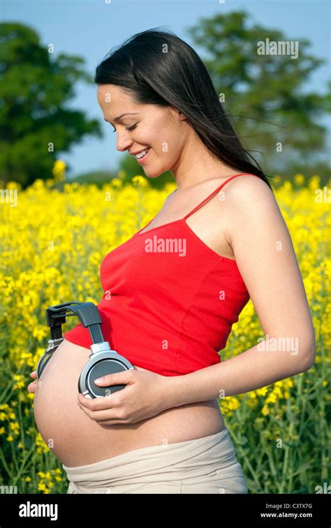 Pregnant Woman Playing Music To Her Unborn Baby Stimulation Stock