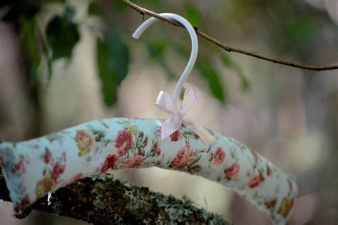 An Ornament Hanging From A Tree Branch With Flowers On Its End