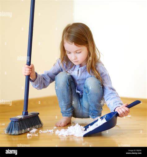 Adorable Little Girl Helping Her Mom To Clean Up At Home Stock Photo