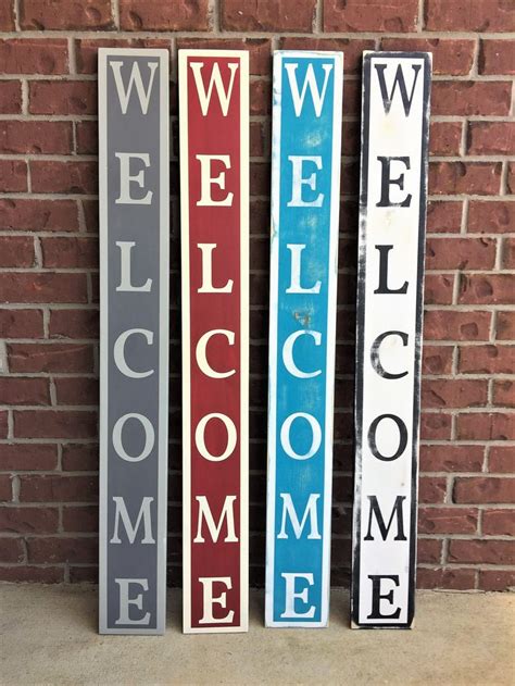 Three Wooden Welcome Signs Sitting Next To A Brick Wall