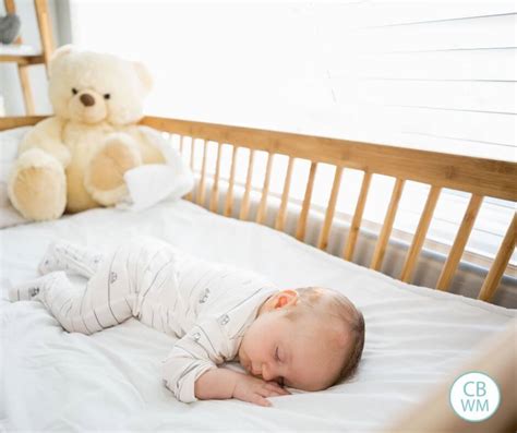 Baby Sleeping In Cosleeper Crib Attached To Parents Bed Stock Photo