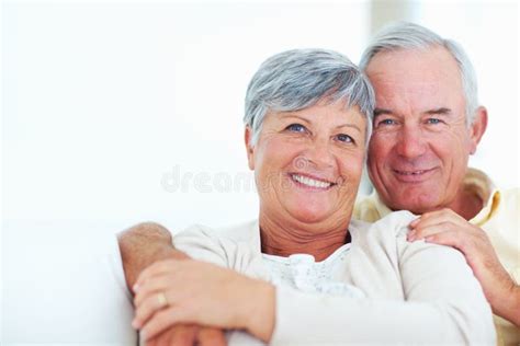 Sheer Joy Closeup Of Cheerful Mature Couple Laughing Together While Sitting At Home Stock